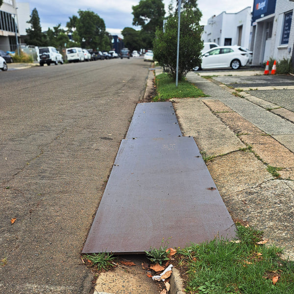 Steel road plates creating a ramp to driveway