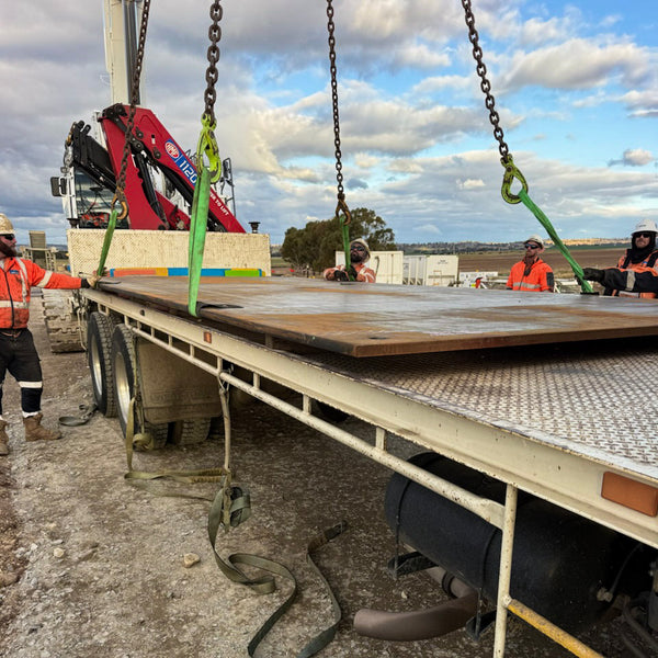Contractors unloading road plate from truck